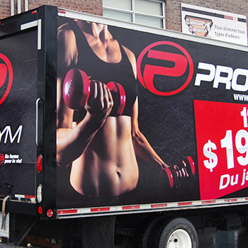 Wrap commercial sur un camion cube de Pro Gym servant de panneau publicitaire pour les promotions